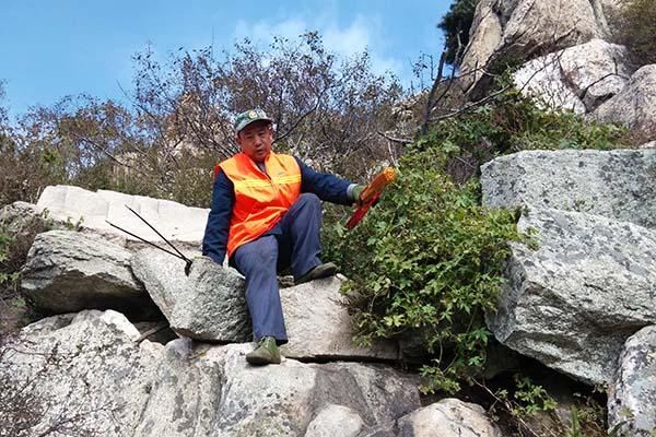 泰山环卫工悬崖边捡垃圾 游客称不扔你就失业了